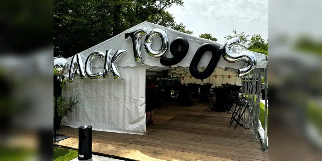 Entrée d’un chapiteau 6x15 pour fête familiale sur le thème des années 90