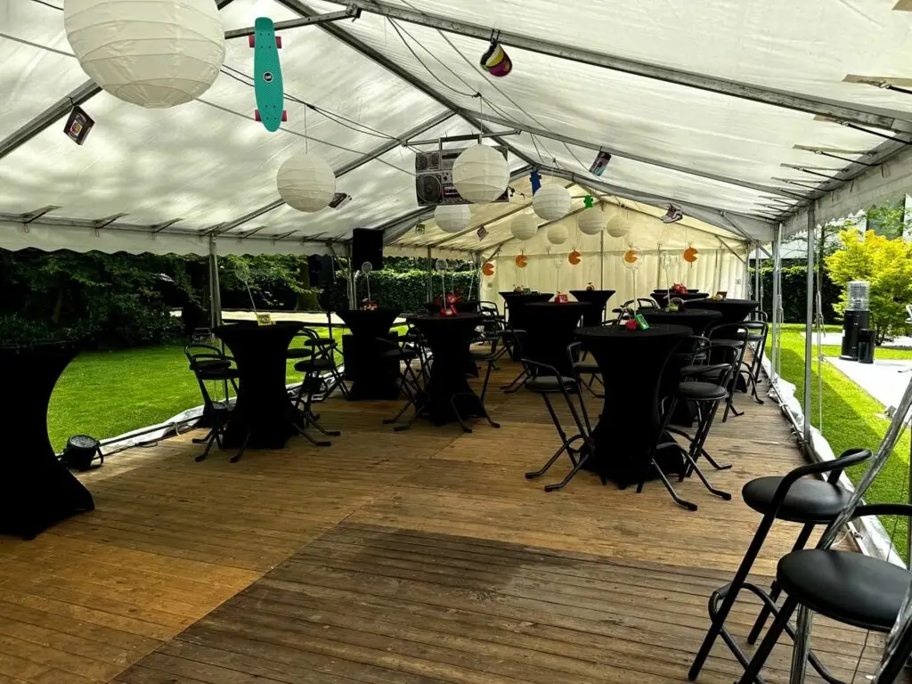Intérieur d’un chapiteau 6x15 aménagé pour une fête familiale sur le thème des années 90