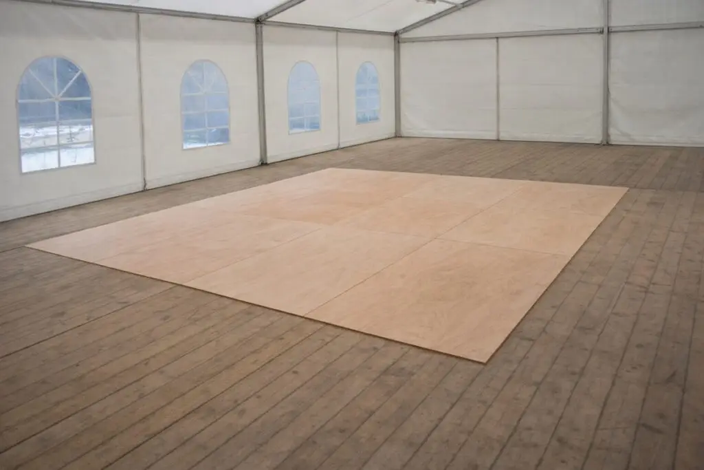 piste de danse en bois installée dans un chapiteau ou une tente de réception pour événement